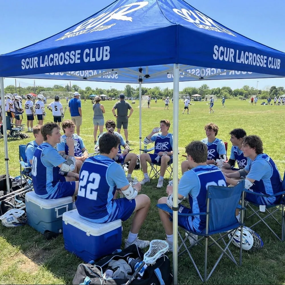Custom blue SCUR Lacrosse Club canopy tent shading players at a tournament