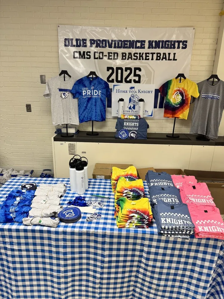 Spirit wear table of custom Olde Providence Knights basketball t-shirts and water bottles